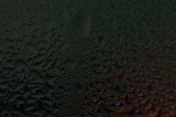 water drops on wet window glass with city lights