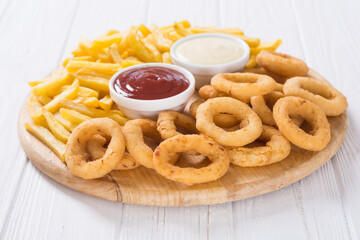 French fries and onion rings with sauces