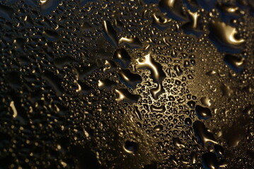 water drops on wet window glass with city lights