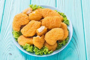 Chicken nuggets in plate on rustic background