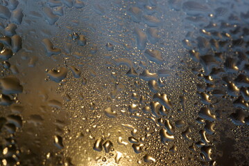 water drops on wet window glass with city lights