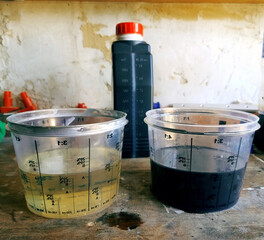 Two measuring glasses with clean and used engine oil