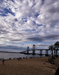 Fototapeta na wymiar Playa y puente con nubes
