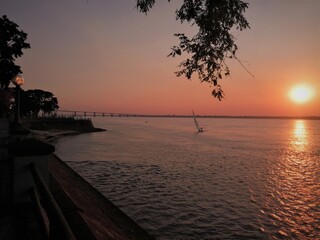 Costanera de Corrientes - costa del r&iacute;o Paran&aacute;- al atardecer, velero y puente 