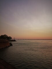 Costa del río Paraná al atardecer y puente  