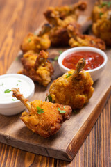Chicken wings nuggets with sauces on wooden background .