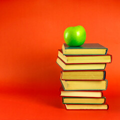 stack of books and green apple. symbol of knowledge and study, education and development. space for text