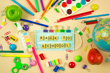 concept of back to school and coronavirus pandemic. medical mask and school stationery. social distance and education