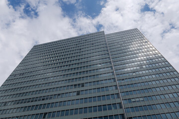 Fototapeta premium Close up detail of modern glass facade with rectangular windows frame system of office building against blue sky. Abstract Architectural Geometry elements with urban metropolis concept.