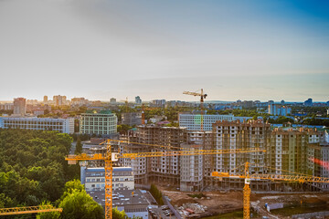 Fototapeta premium New Construction Site with Building Cranes Against Sunny Sky.