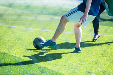 Selective focus to soccer player control and shoot ball to goal with goalkeeper. Soccer players fighting with goalkeeper.