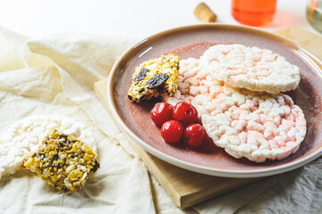 Rice Crackers with Cherry Syrup and Cereal Bar, and some cherries, flowers and white background.