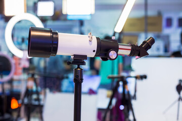 Telescope mounted on a tripod. White monocular telescope in store shop.