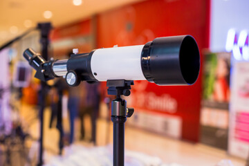 Telescope mounted on a tripod. White monocular telescope in store shop.