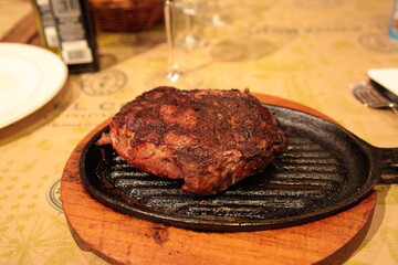 Grilled Argentina rib eye beef steak meat on table at a traditional Argentinean restaurant, in Buenos Aires, Argentina.