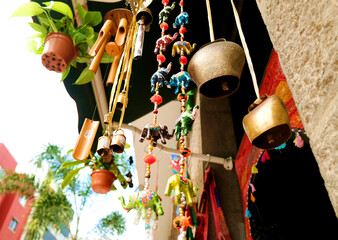 Decorative tin yak and oxen bells, beads and paper elephant figures - symbols and signs of indian (hindu) and buddhist religions and tradition, low angle view. - obrazy, fototapety, plakaty