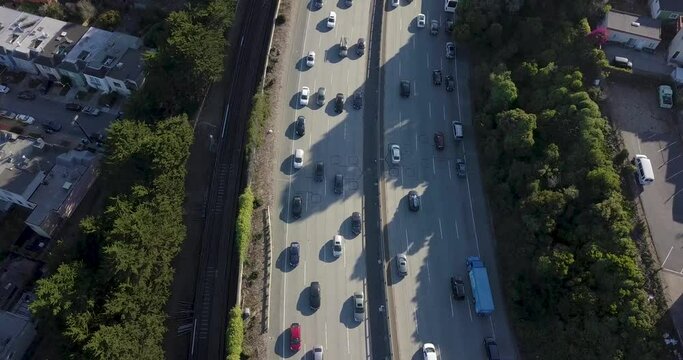 Highway traffic during sunset and cars going in opposite direction. Bart train on the track and muni on the road camera move forward