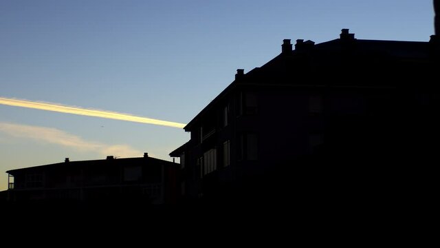 193/5000
Backlight of some buildings at dawn while the camera turns from left to right and shows us the sunrise with its blue orange purple colors and the birds flying to start the day.