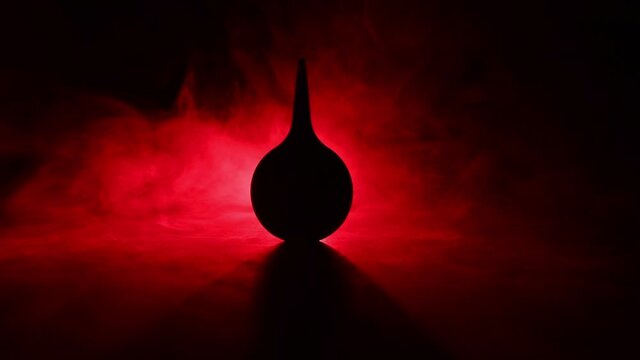 Blue enema on dark background with backlight. Creative artwork decorated with light. Selective focus
