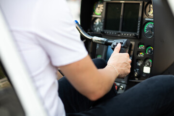 Portrait of commercial pilot in uniform sitting inside helicopter cabin.