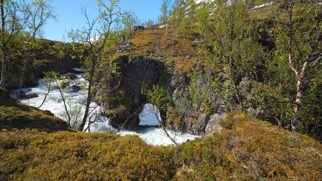 Pan view of rapids in the highlands of the Lyngen alps, on a sunny, summer day, in North Norway