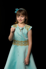 Cute little girl is playing with sparkler. Black background.