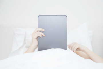Woman Lying and Playing Tablet on the Bed