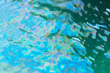 Colorful oil stains on the water surface.