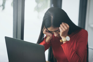 Tired overworked young asian freelancer working with a laptop tired after unemployed.