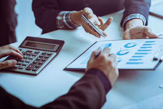 Business man meeting and discussing document and anylysis counting cost with calculator in office.