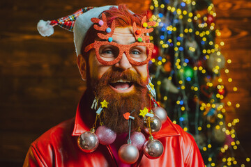 Merry christmas and happy new year. New year - fun party with funny Santa. Christmas or New Year barber shop concept. Beard with bauble. Santa in barbershop. Christmas style for modern Santa.