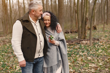 Seniors in a forest. People walks. Family with spring's flowers.