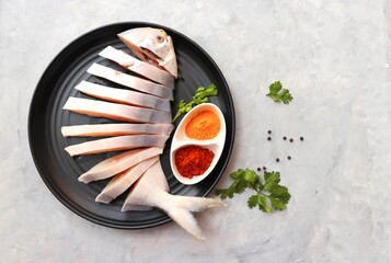 Indian fish fry recipe- fresh whole Pomfret fish or butter fish or Poplet cut into slices. cleaned and ready for frying along with spices. ingredients and recipe background with copy space