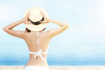 Rear view of Asian woman with bikini and hat relaxing