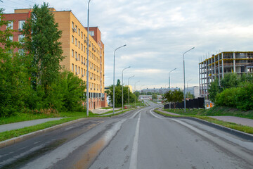 Fototapeta premium An empty highway with an urban landscape in Siberia