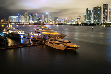 Miami city night. Beautiful colorful city of Miami Florida skyline and bay with night clouds.