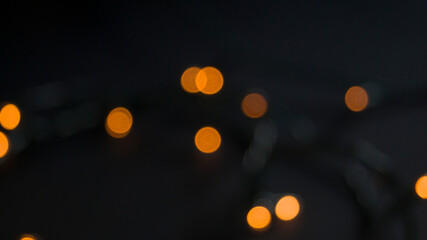 Blurry bokeh light on dark background. Abstract urban night light bokeh. Defocused background for holidayy on Christmas or Holiday concept.