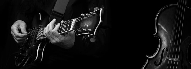 Music concept. electric guitar and violin. guitarist playing electric guitar and violin fragment black and white. rock music and classical music © Oleksii