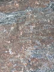 Background texture: the structure of a large stone. Granite boulder close up. Irregularities and cracks in the stone rock. Concept - stone, hardness