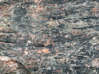 Background texture: the structure of a large stone. Granite boulder close up. Irregularities and cracks in the stone rock. Concept - stone, hardness
