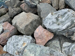 Background texture: many large stones of different shapes. A pile of granite boulders. Concept - stone, hardness, foundation