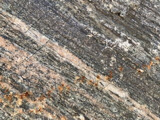 Background texture: the structure of a large stone. Granite boulder close up. Irregularities and cracks in the stone rock. Concept - stone, hardness