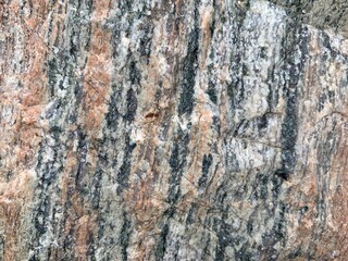 Background texture: the structure of a large stone. Granite boulder close up. Irregularities and cracks in the stone rock. Concept - stone, hardness