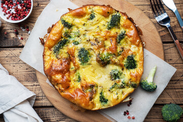 Baked omelet with broccoli on a wooden Board and background. Healthy diet food dish.