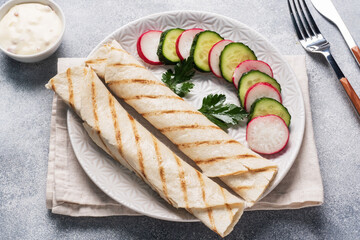 Roll with cheese and herbs. Grilled pita bread with filling. Cucumber radish salad. The concept of a healthy Breakfast.