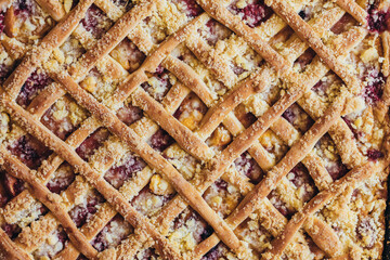 Homemade sweet cherry pie as a whole on an iron platter, top view, close-up. Pattern background of pie.