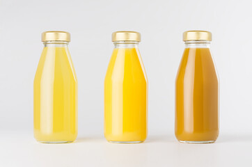 Orange, yellow fruit juices collection in glass bottles with cap in row mock up on white background, template for packaging, advertising, design product, branding.