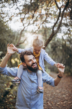 young, stylish bearded father walking with his little daughter in nature at sunset. Family photos of father and one child. selective focus, noise effect