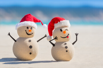 Two Sandy Christmas Snowmen are celebrating Christmas on a beautiful beach, one of them is only in focus
