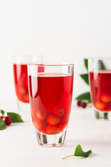 Summer delicious refreshing cherry compote with pulp and with ice in glasses on a white background